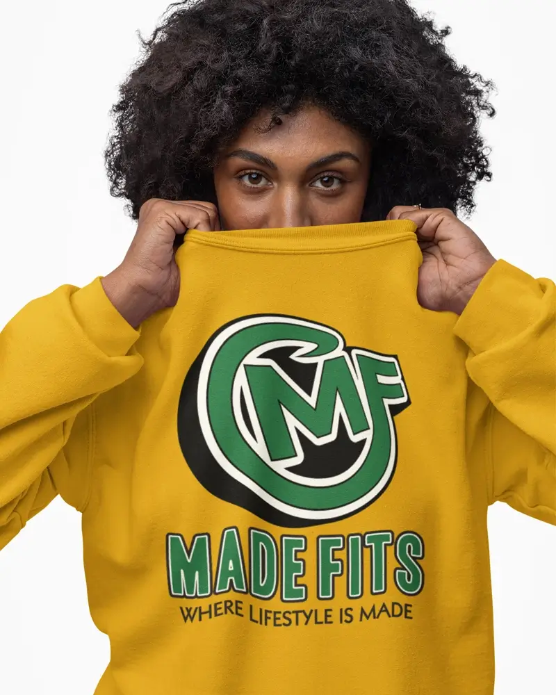 Girl posing for picture wearing a gold MadeFits sweatshirt.