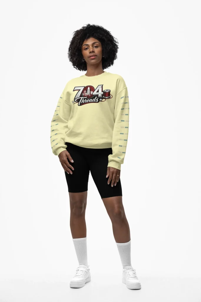 Woman posing for a photo wearing a cream colored 704 Threads sweatshirt.